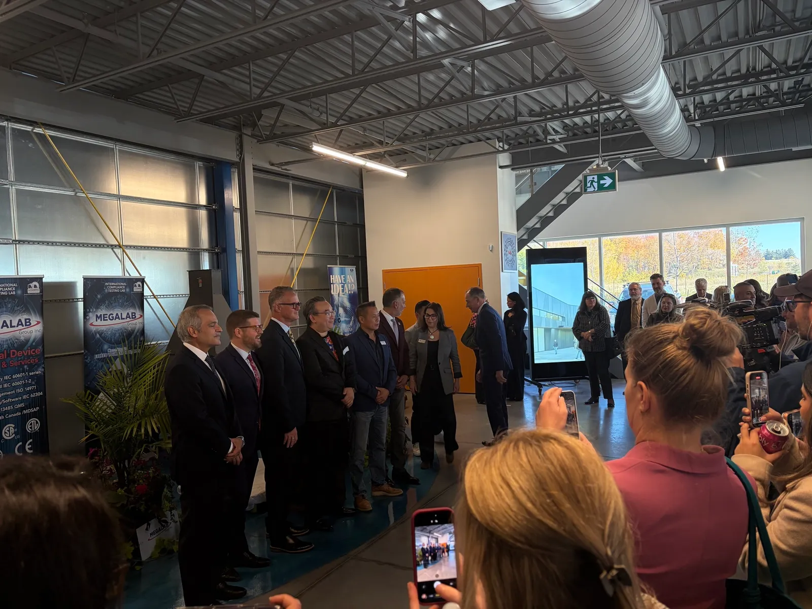 Speakers and partners line up beside Megalab banners at the Audacity North announcement in Aurora, Ontario
